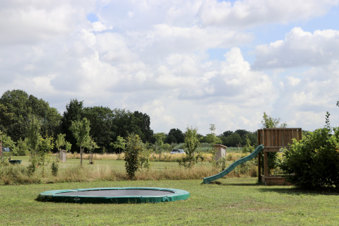 Speelplaats met trampoline en glijbaan bij Camping de Heerlijkheid Vorenseinde, Noord-Brabant, Nederland.