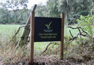 Skilt ved Camping de Heerlijkheid Vorenseinde, et feriepark i Nordbrabant, Holland, omgivet af natur.