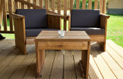 Tuinset van hout met twee stoelen en een tafel op een terras voor een safaritent in het zonlicht.