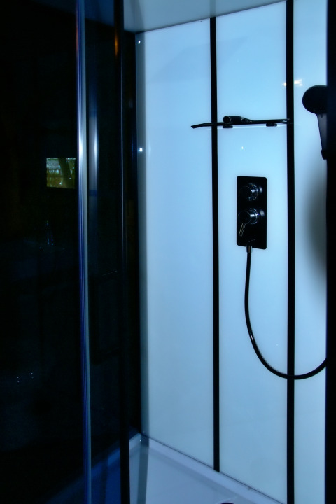 Moderne Dusche im Safari-Zelt bei Camping La Dolce Vita in den Niederlanden mit Glaspaneelen.