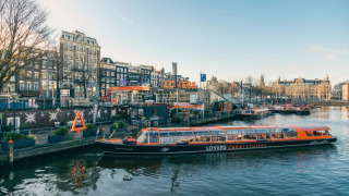 Vista panorámica de un barco de LOVERS canal cruises en Ámsterdam con decoraciones y edificios festivos.