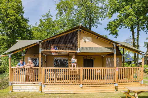 Familia disfruta en la tienda safari Stuuflodge DeLuxe de Kampeerdorp de Zandstuve, Países Bajos.