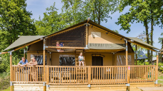Familia disfruta en la tienda safari Stuuflodge DeLuxe de Kampeerdorp de Zandstuve, Países Bajos.