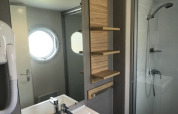 Moderne badeværelse i Lodge XL ved Vakantiepark Bergumermeer med bruser, håndvask og rundt vindue.