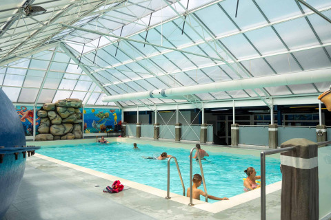 Innenpool mit schwimmenden Gästen im Vakantiepark Bergumermeer, Friesland, Niederlande.