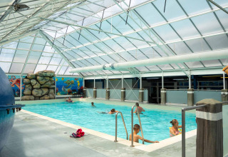 Innenpool mit schwimmenden Gästen im Vakantiepark Bergumermeer, Friesland, Niederlande.