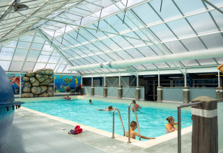 Indoor swimming pool with people enjoying the water at Vakantiepark Bergumermeer, Friesland, Netherlands.