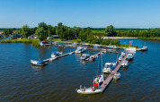 View of boats docked at the marina in Vakantiepark Bergumermeer, Friesland, Netherlands, on a sunny summer day.
