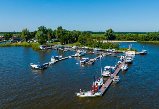 Udsigt over små både og lystbåde i en marina ved Vakantiepark Bergumermeer, Friesland, Holland, på en klar dag.