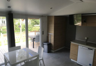 Interior del Lodge XL en Vakantiepark Bergumermeer, Países Bajos, con ventanales y cocina moderna.