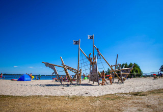 Børn leger på et piratskibslegeplads ved stranden i Vakantiepark Bergumermeer, Friesland, Holland.