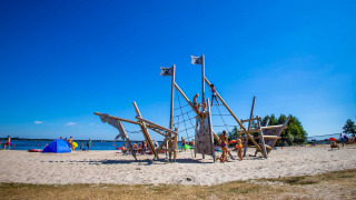 Niños jugando en un parque infantil de barco pirata en la playa Vakantiepark Bergumermeer, Friesland.
