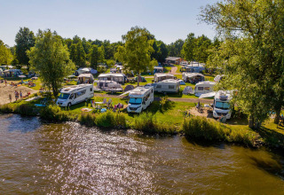 Motorhomes and tents by the lake at Vakantiepark Bergumermeer holiday park in Friesland, Netherlands.