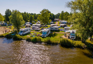 Autocaravanas y tiendas junto al lago en Vakantiepark Bergumermeer, parque vacacional en Frisia, Países Bajos.
