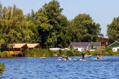 Families kayaking and relaxing by the lake at Vakantiepark Bergumermeer, Friesland, Netherlands, in summer.