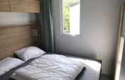 Dormitorio moderno con cama doble y gran ventana en Lodge XL de Vakantiepark Bergumermeer, Países Bajos.