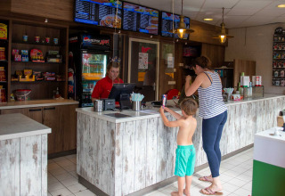 Kunder bestiller mad ved disken på en snackbar i ferieparken Bergumermeer i Friesland, Holland.