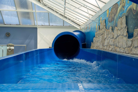 Tobogán azul cubierto de agua en Vakantiepark Bergumermeer, parque vacacional en Friesland, Países Bajos.