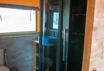 Bathroom inside a Safari tent at Vakantiepark Bergumermeer in the Netherlands, with shower and toilet.