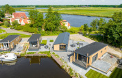 Luftfoto af moderne Waterlodge type 2 ved Vakantiepark Bergumermeer i Holland, med udsigt til sø.