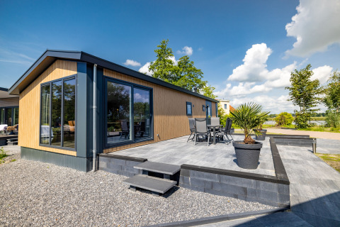 Modern Waterlodge type 2 at Vakantiepark Bergumermeer in the Netherlands, with patio and garden furniture.