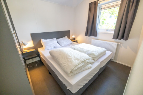 Dormitorio luminoso y acogedor en la Waterlodge tipo 2 en Vakantiepark Bergumermeer, Países Bajos.