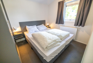 Lyst og hyggeligt soveværelse i Waterlodge type 2 på Vakantiepark Bergumermeer, Nederlandene.