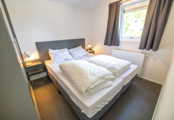 Lyst og hyggeligt soveværelse i Waterlodge type 2 på Vakantiepark Bergumermeer, Nederlandene.
