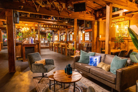 Zona lounge accogliente in un parco vacanze con arredi in legno, divani comodi e tavolini.