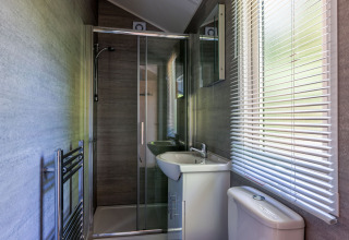 Modernes Bad in der Forest Cottage im Recreatiepark de Paalberg, Niederlande, mit Dusche und Jalousien.