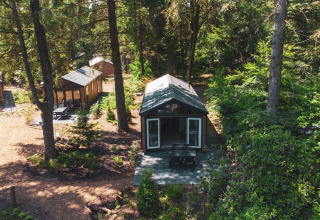 Vue aérienne du Forest Cottage à Recreatiepark de Paalberg, Pays-Bas, niché parmi les arbres et chalets boisés.