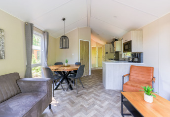 Moderne opholdsstue og køkken i Forest Cottage, Recreatiepark de Paalberg, Nederlandene med hyggelig indretning.