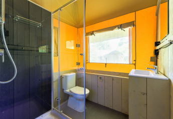 Bagno moderno in una tenda glamping al Recreatiepark de Paalberg, Paesi Bassi, con doccia e finestra ampia.