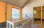 Interior view of a glamping safari tent with wooden furniture at Recreatiepark de Paalberg, Netherlands.