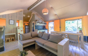 Interior de una tienda glamping safari con salón, cocina y comedor en Recreatiepark de Paalberg, Países Bajos.