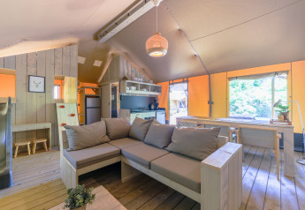 Intérieur d’une tente safari glamping avec salon, cuisine et salle à manger à De Paalberg, Pays-Bas.