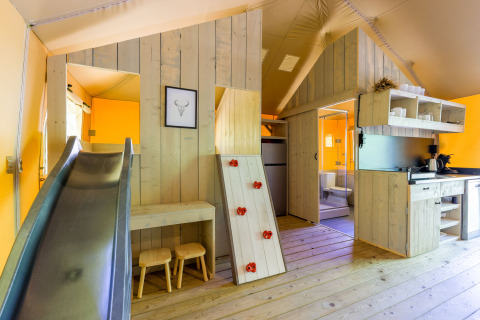 Interior de la Glamping Tent en Recreatiepark de Paalberg en los Países Bajos con tobogán y zona de juegos.
