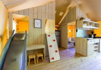 Intérieur de la Glamping Tent au Recreatiepark de Paalberg aux Pays-Bas avec toboggan et espace jeux.