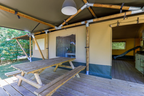 Holzbänke und Tisch auf der Veranda eines Glamping-Zelts im Recreatiepark de Paalberg in den Niederlanden.