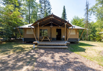 Une tente safari glamping au Recreatiepark de Paalberg aux Pays-Bas, entourée de verdure et d’arbres.