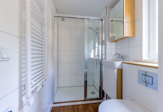 Baño pequeño y moderno en Heide Lodge, Recreatiepark de Paalberg, Países Bajos, con ducha y lavabo.