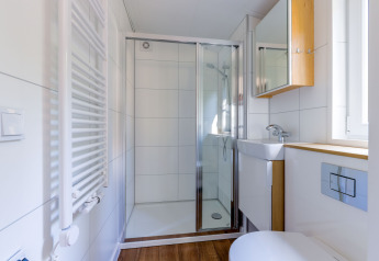 Baño pequeño y moderno en Heide Lodge, Recreatiepark de Paalberg, Países Bajos, con ducha y lavabo.