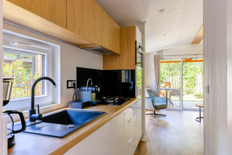 Modernes, kleines Küchendesign in der Heide Lodge im Recreatiepark de Paalberg, Niederlande, mit Gartenblick.