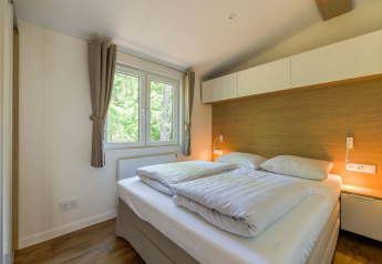 Camera luminosa alla Heide Lodge al Recreatiepark de Paalberg, Paesi Bassi, con letto matrimoniale comodo.
