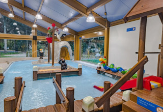 Indendørs legeplads med soppebassin og vandleg for børn på en feriepark med glamping faciliteter.