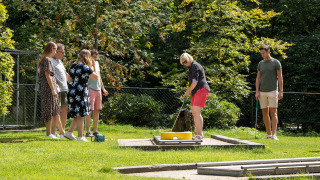 Grupo de personas juega minigolf al aire libre en Recreatiepark de Paalberg, Gelderland, Países Bajos.