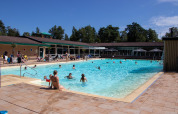 Piscina all'aperto con famiglie e bambini che si godono il sole al Recreatiepark de Paalberg, Gelderland.