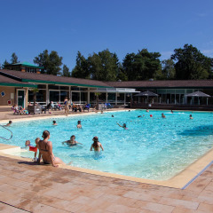 Piscina al aire libre con familias y niños en Recreatiepark de Paalberg, Gelderland, Países Bajos, disfrutando el sol.