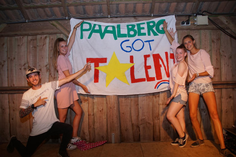 Grupo de jóvenes posando frente a un cartel de 'Paalberg Got Talent' en un parque de vacaciones en Gelderland, Países Bajos.