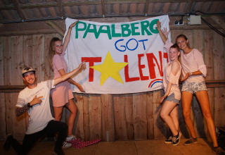 Jongeren poseren bij een 'Paalberg Got Talent'-banner op een vakantiepark in Gelderland, Nederland.